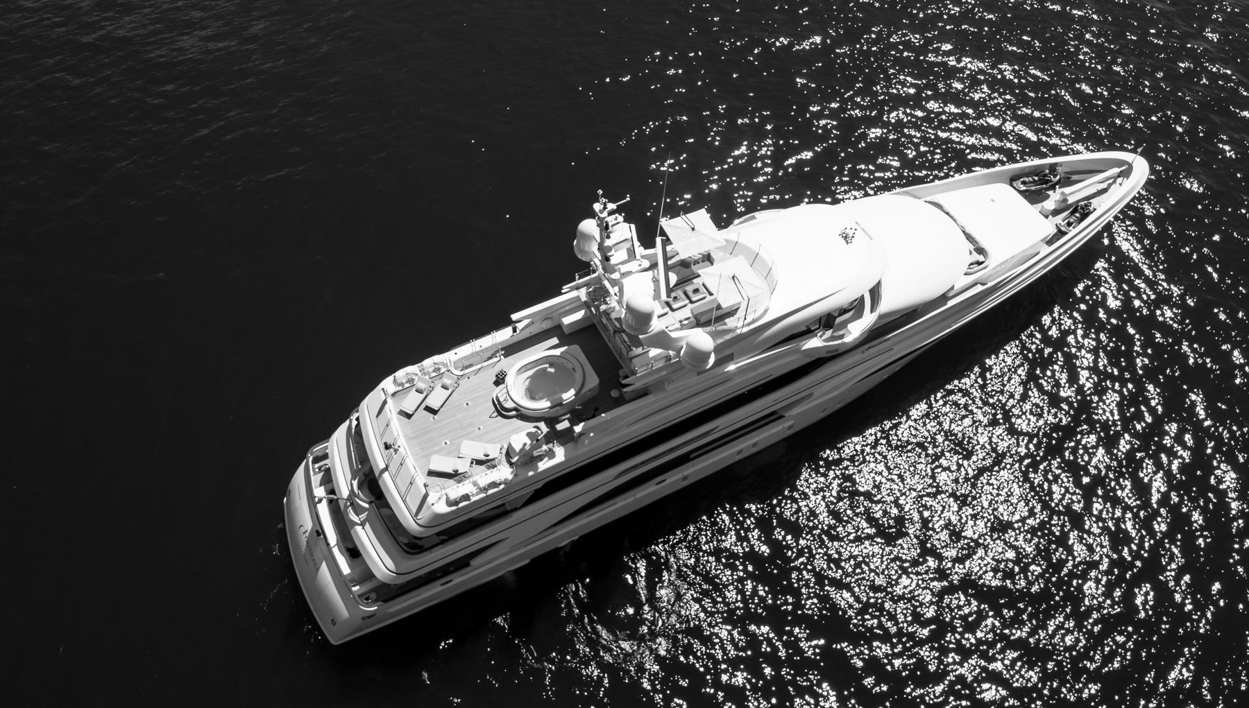 Aerial view of a motor superyacht at anchor over clear water