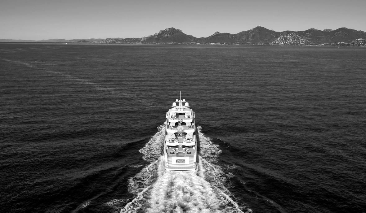 A superyacht under way leaving a wake, seen from above on open sea