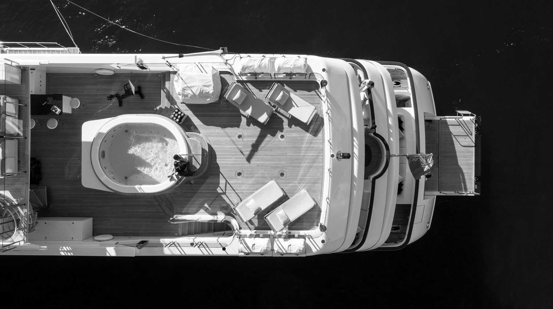Aerial view of a superyacht sun deck with a spa pool and loungers